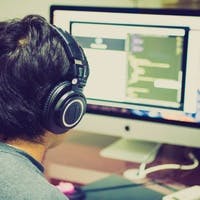 Engineer with headphones on writing code