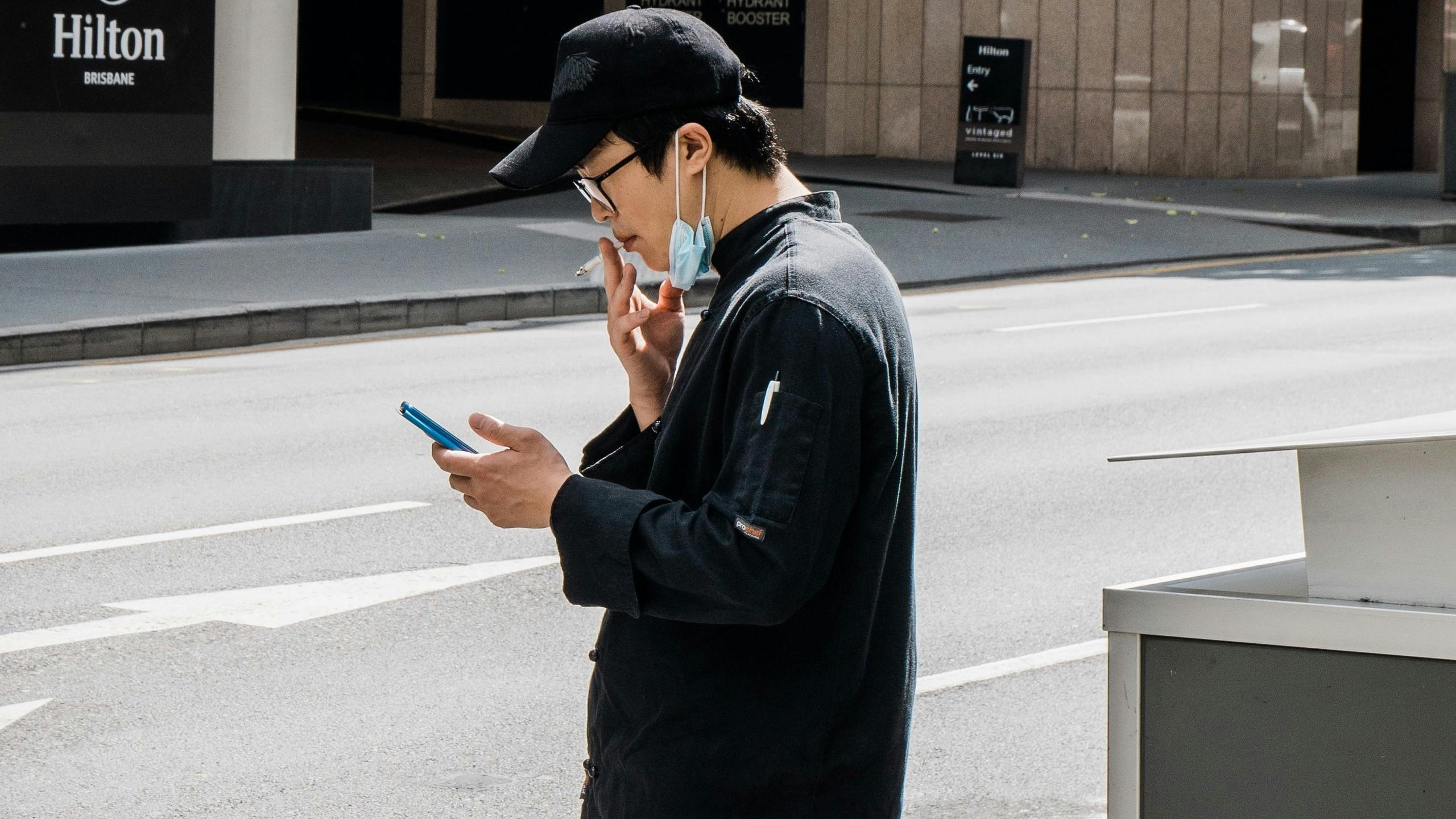 Man smoking while checking phone