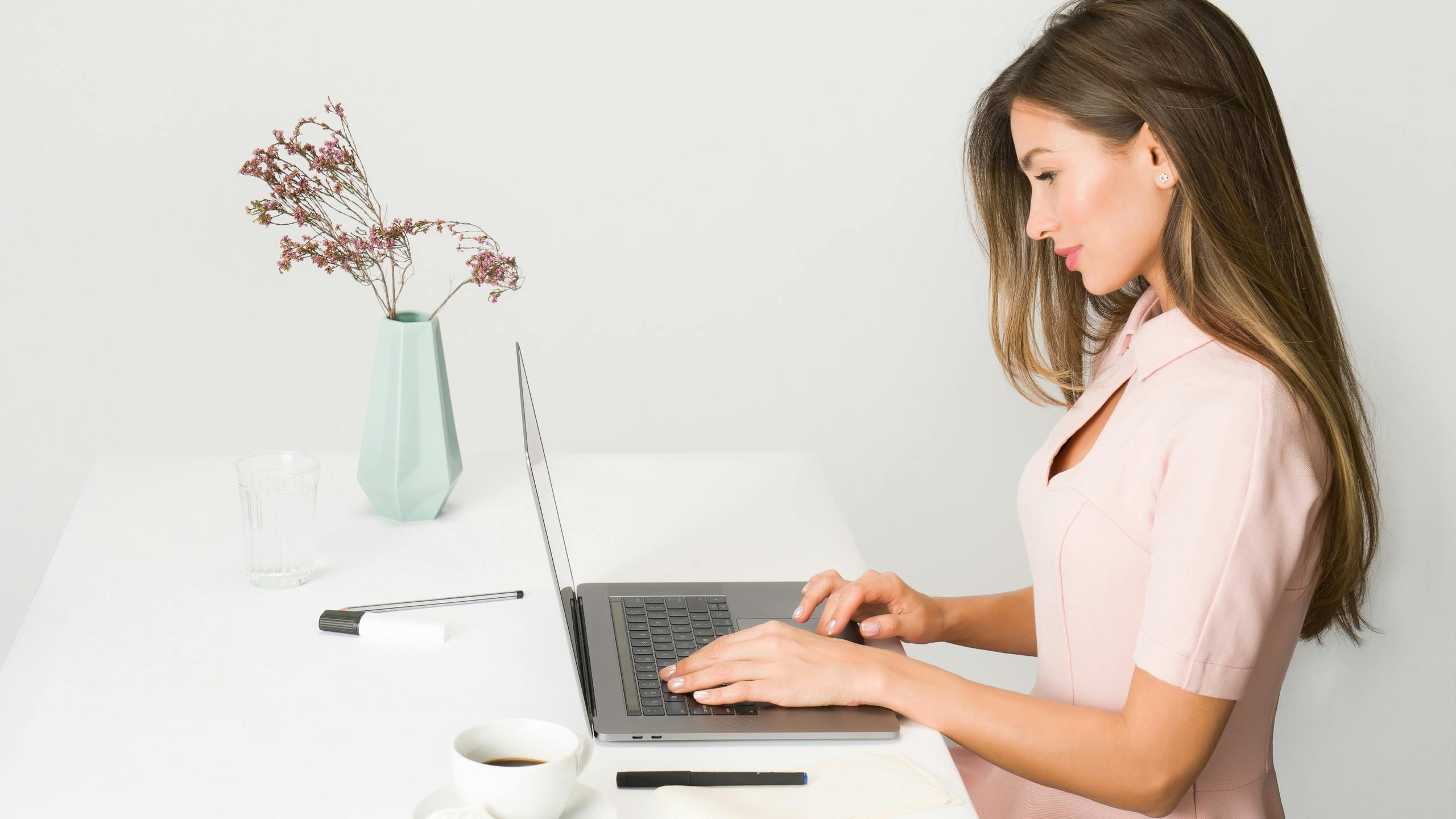 Woman working at desk with coffee and laptop