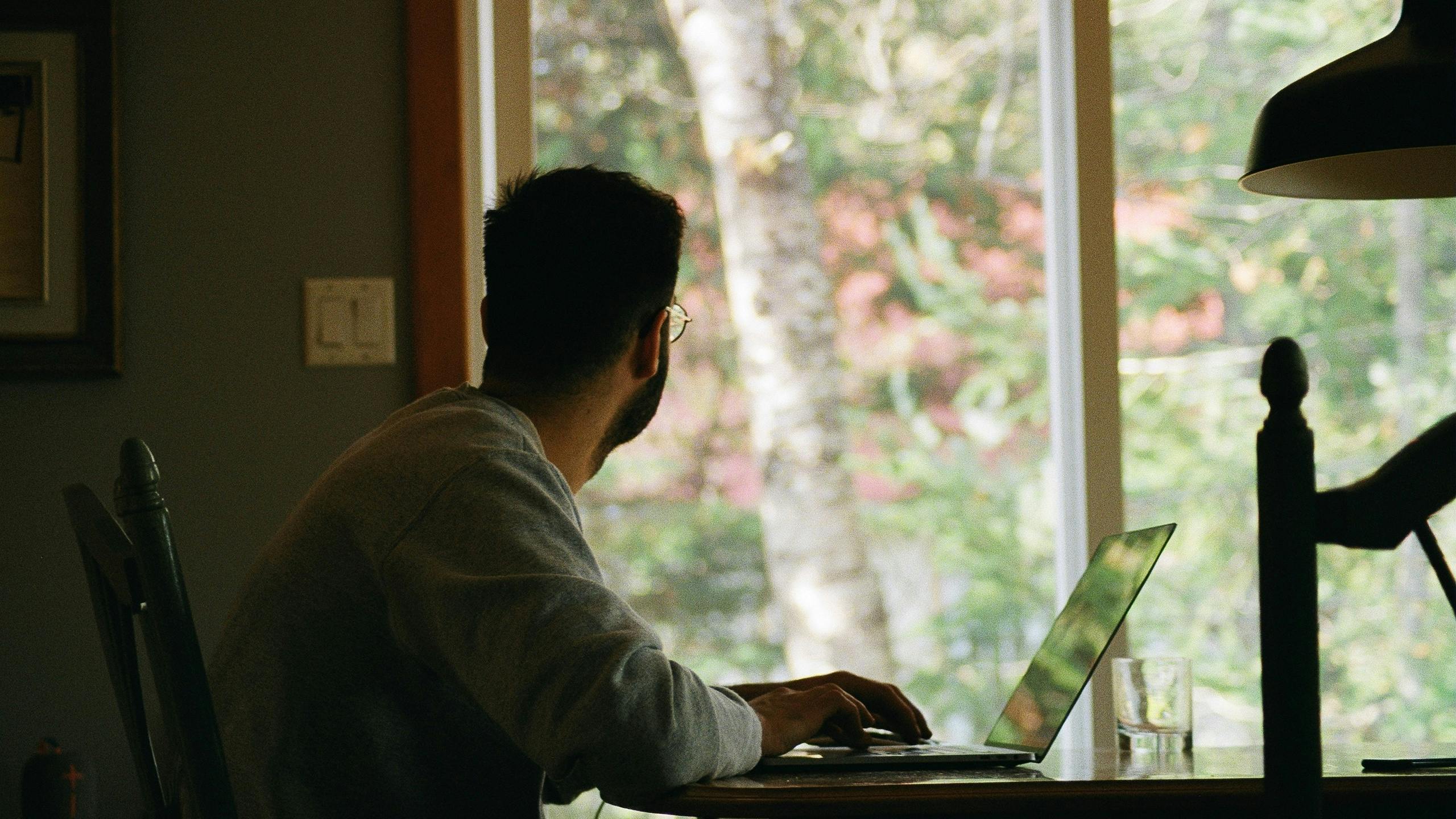 Man working from home staring out the window