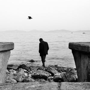 Man standing near edge of lake