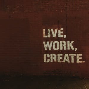 Live, work, create on brick wall