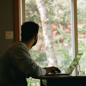 Man working from home staring out the window