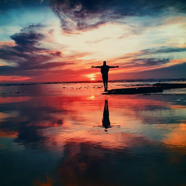 Man standing near ocean during sunset