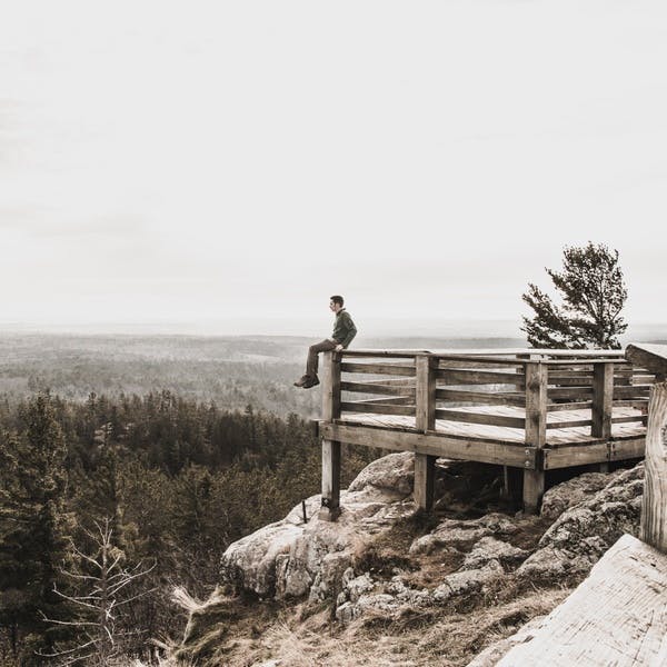 Man sitting on deck overlooking mountain