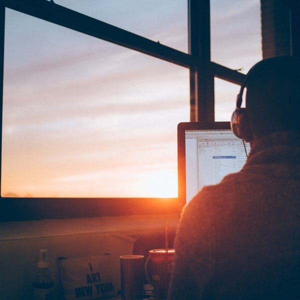 Man working on computer during sunset